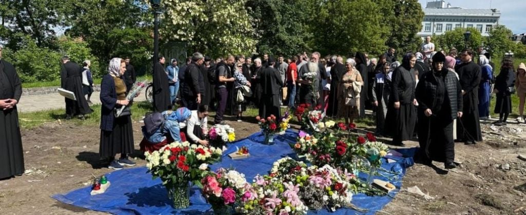 Киевляне и духовенство города несут цветы к уничтоженному Десятинному храму